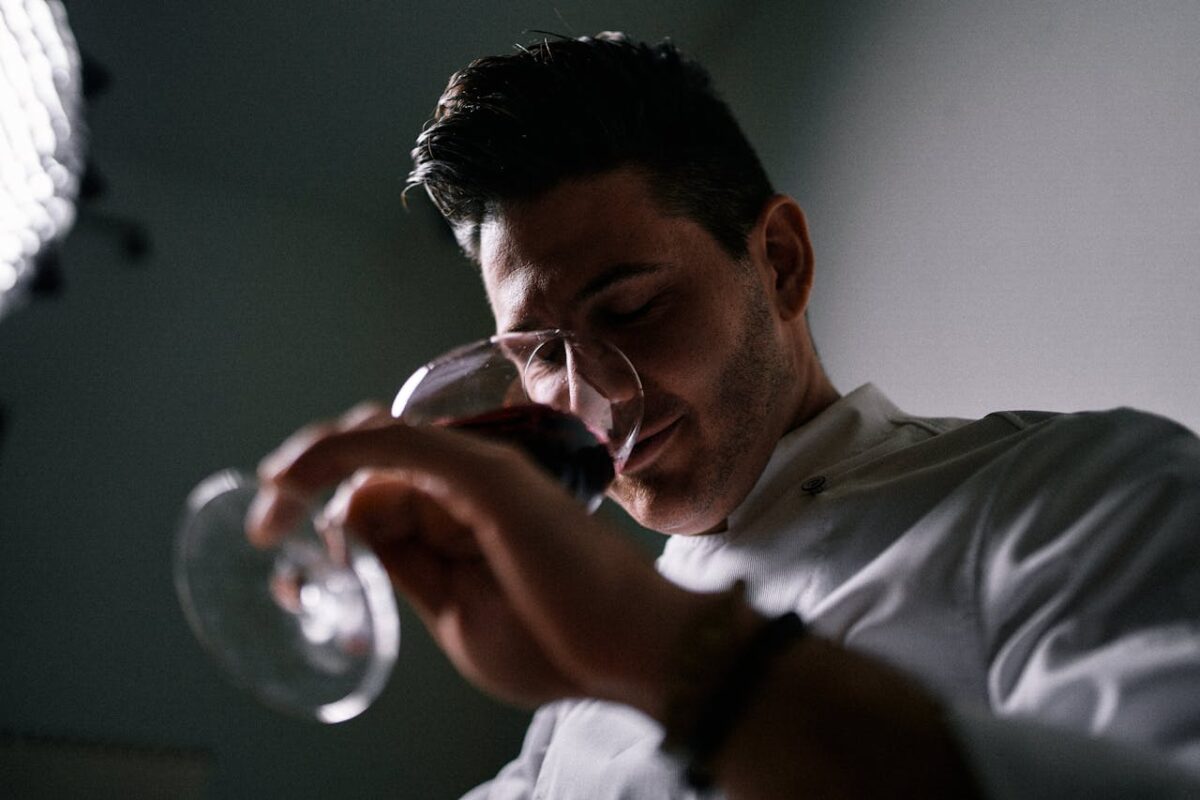 Close-up of a man holding a glass of red wine in a relaxed indoor setting in Miami.