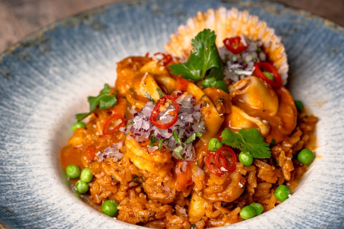 Mouthwatering seafood risotto garnished with fresh coriander and sliced red chilies.